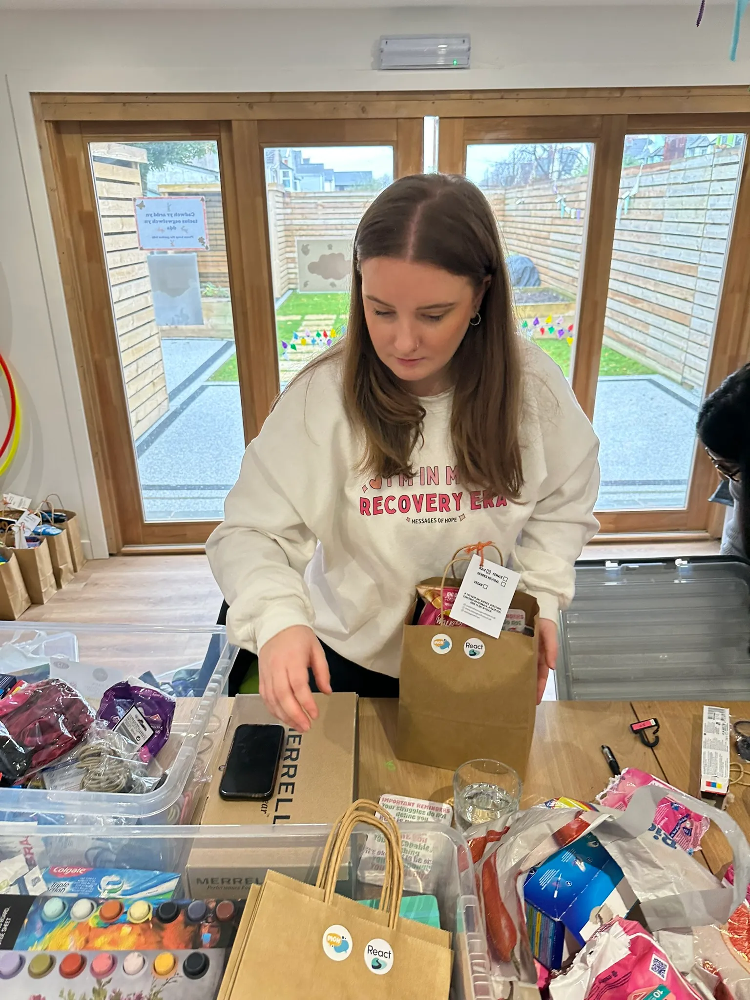 A volunteer packing a Hope Bag with essentials at a sorting table