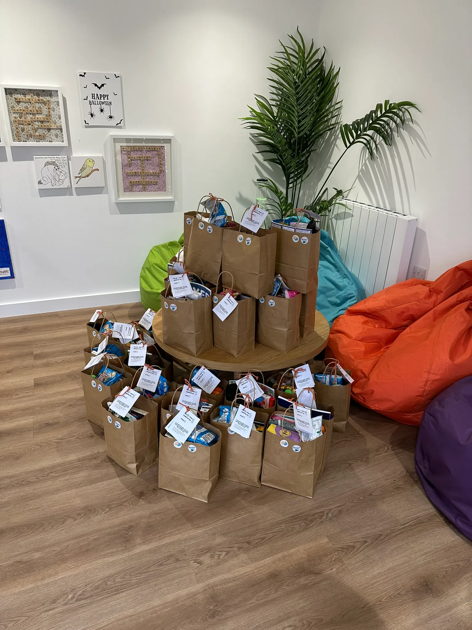 Dozens of packed Hope Bags arranged on and around a table, ready for delivery after a bag packing day